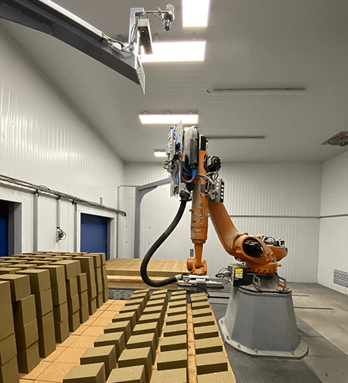 Industrial robot picks bricks from a waggon by making use of a robot vision system installed above the scene